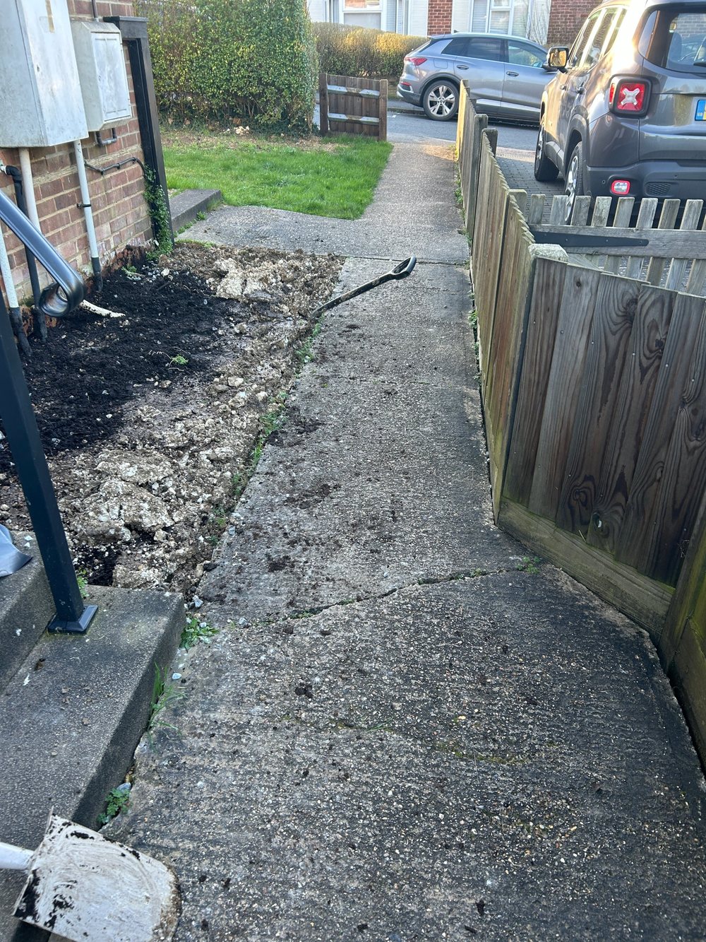 Before: bare, freshly dug soil beside a concrete path