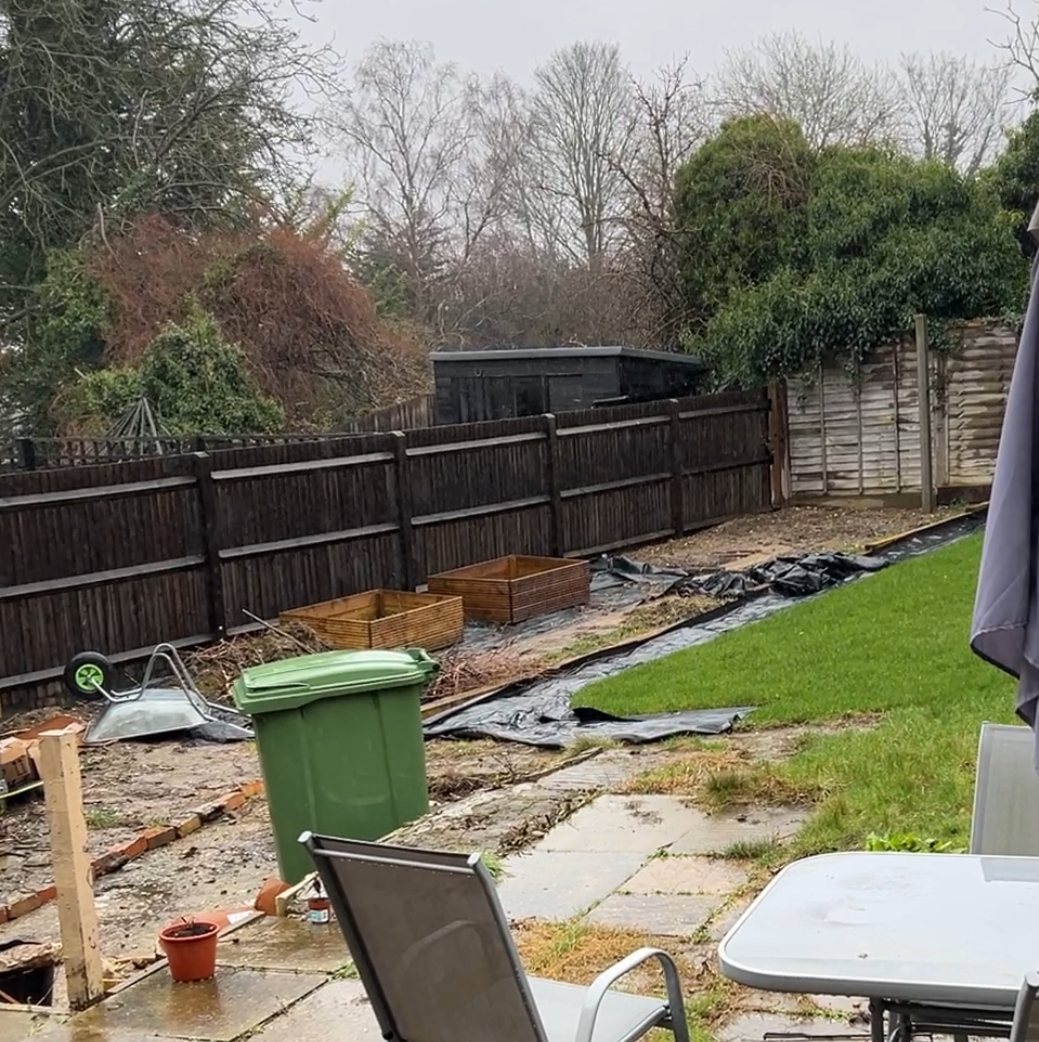 Before: a cleared back garden with black membrane laid and two empty raised beds beside a dark fence